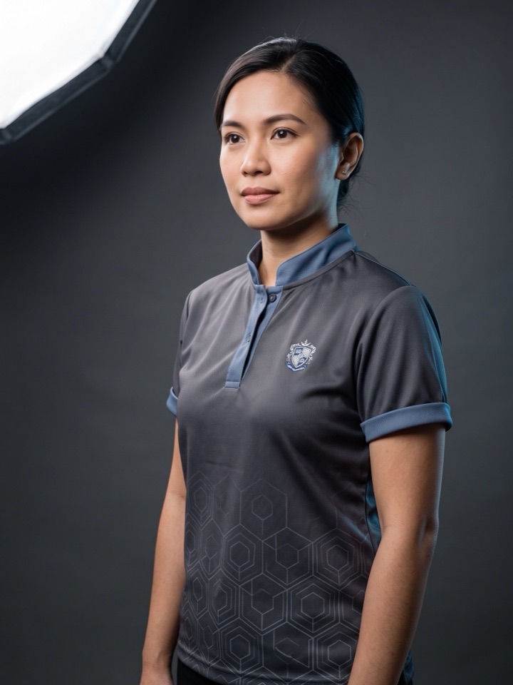 Staff member in a charcoal corporate polo with embroidered crest