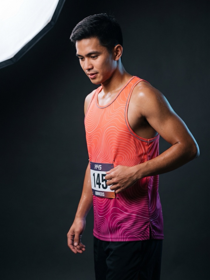 Runner in an orange to magenta gradient race singlet with a bib